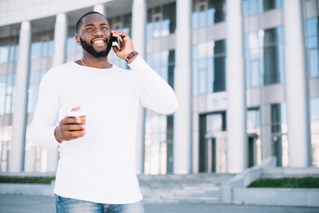 Uomo sorridente che parla sul telefono