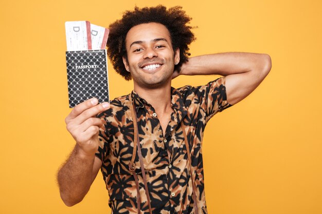 Smiling man standing holding passport.