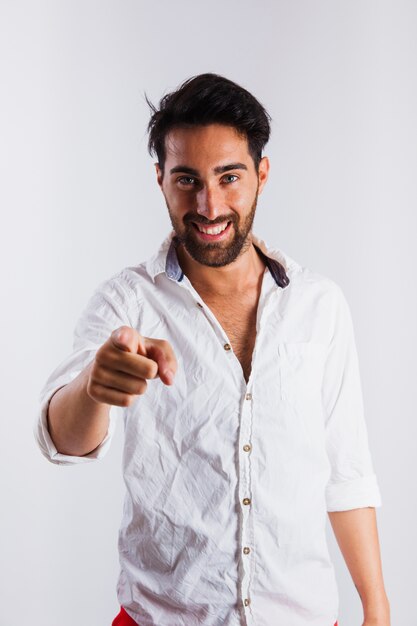 Smiling man in summer wear making pointing gesture