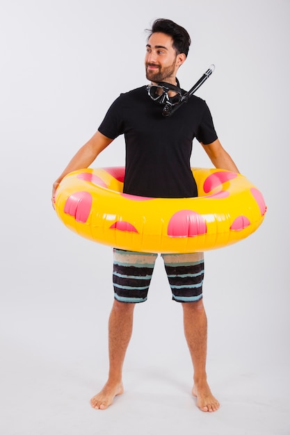 Smiling man in summer wear with floating tube and snorkel