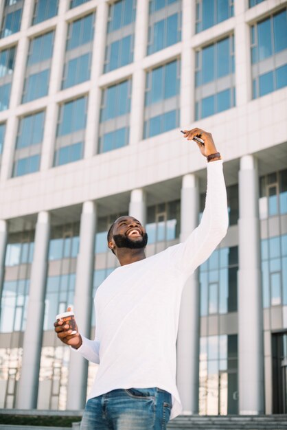 Smiling man taking selfie near building