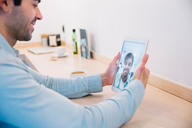 Foto gratuita uomo sorridente prendendo selfie con tablet