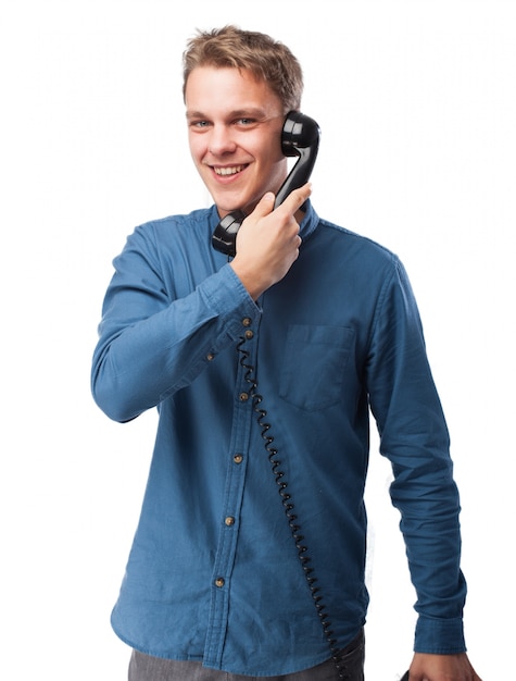 Smiling man talking on an old phone