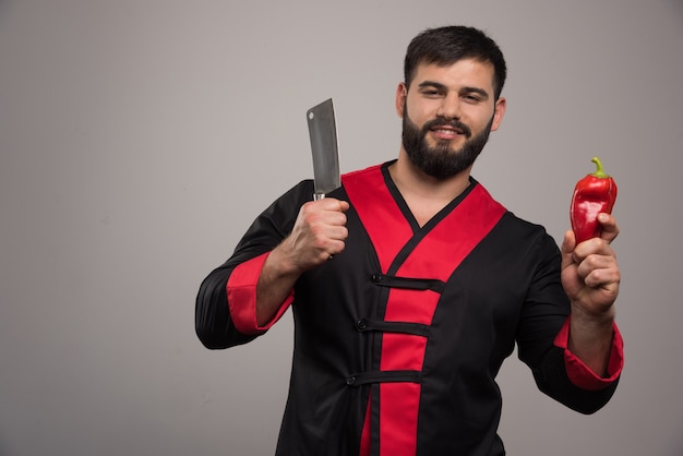 Foto gratuita uomo sorridente con coltello e pepe rosso.