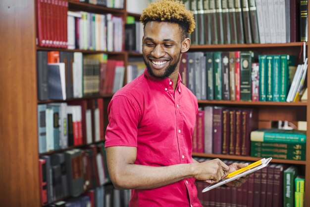 Smiling man with notepads in library