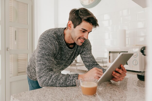 Smiling man with tablet in kitchen