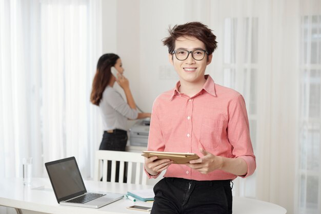 Smiling man with tablet in office