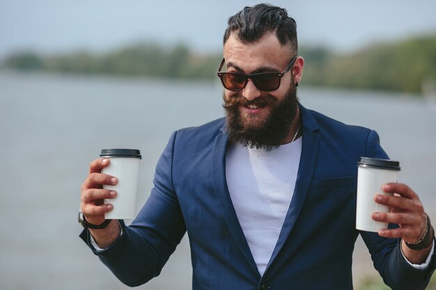 Smiling man with two glasses of coffee