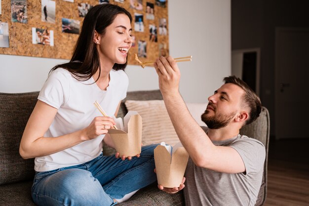 Smiling man and woman having lunch together at home