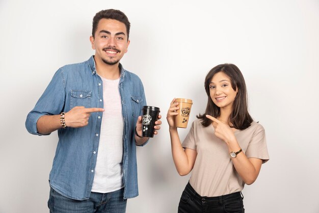 Smiling man and woman with cups of coffee. 