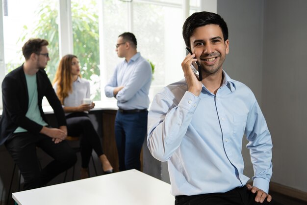 Smiling manager talking on mobile phone