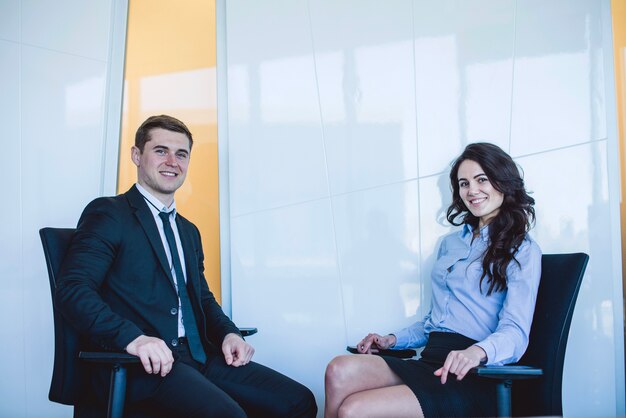 Smiling managers sitting in chairs