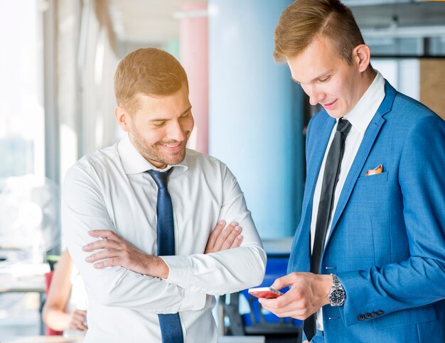 Smiling mature businessman looking at cellphone