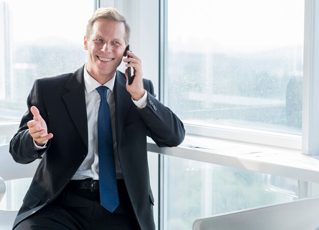Smiling mature businessman talking on mobile phone