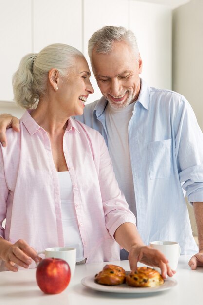 Smiling mature loving couple family standing at the kitchen