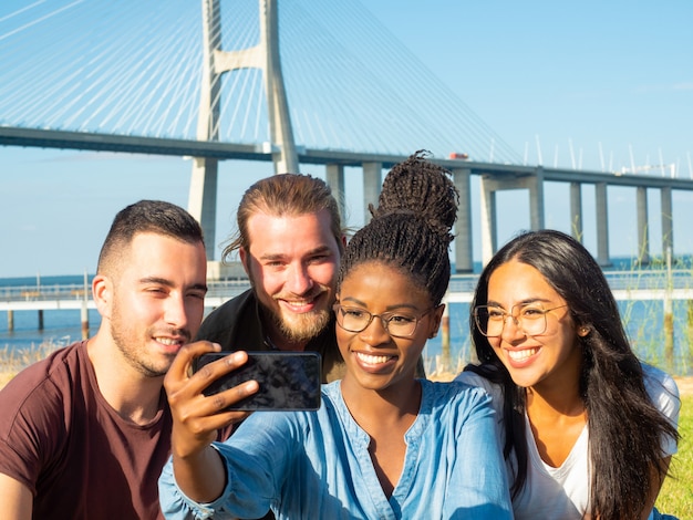 Foto gratuita uomini e donne sorridenti che prendono selfie all'aperto