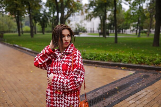 A smiling middle age woman wearing autumn clothes.