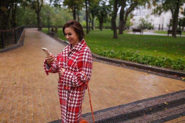 A smiling middle age woman wearing autumn clothes.