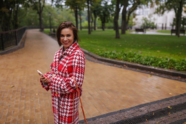 A smiling middle age woman wearing autumn clothes.