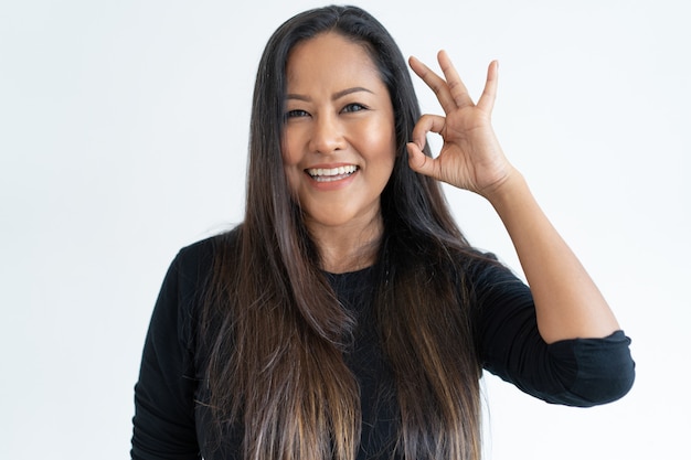 Free photo smiling middle-aged woman showing ok sign