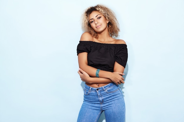 Smiling model woman in trendy jeans posing