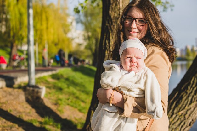 Smiling mother with her baby in the park