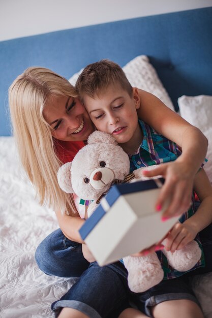 Smiling mother with her son and holding a gift