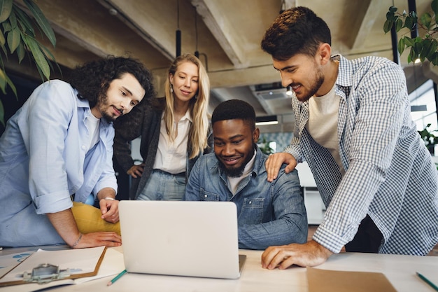 Smiling multiracial coworkers working together at office meeting have a discussion