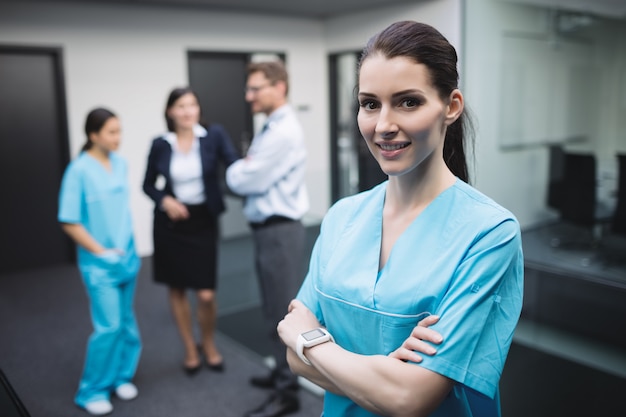 Free photo smiling nurse standing with arms crossed