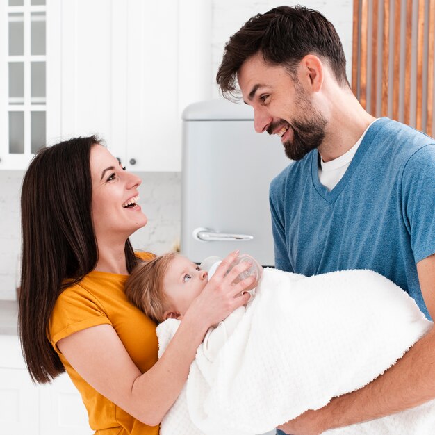 Smiling parents holding baby