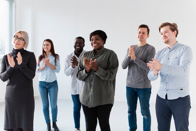 Smiling patients applauding and looking away