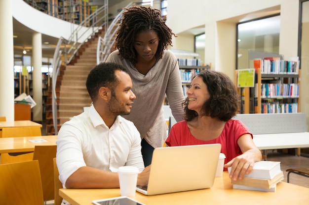 Smiling people communicating at library