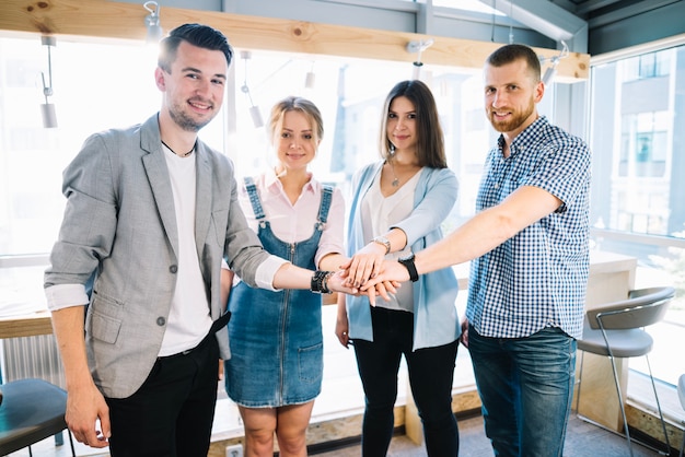 Smiling people holding hands together