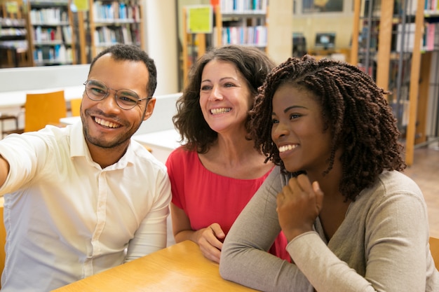 Free photo smiling people posing for self portrait at library