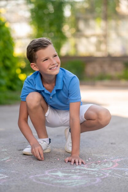 Smiling pleased young boy involved in creative process