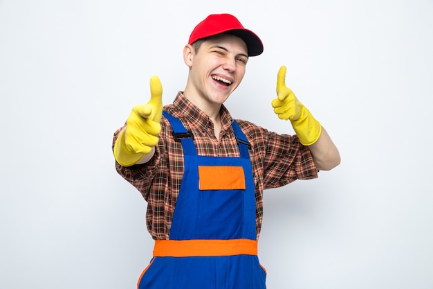 Улыбающиеся очки перед молодым уборщиком в униформе и кепке с перчатками