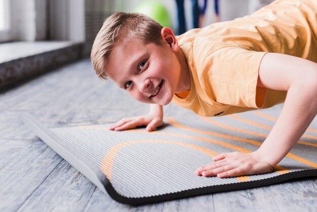 Smiling portrait of a boy exercising looking at camera