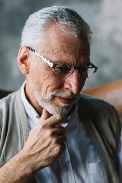 Smiling portrait of an elderly man with hand on his chin