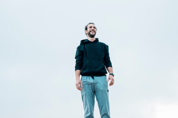 Free photo smiling portrait of a man standing against blue sky
