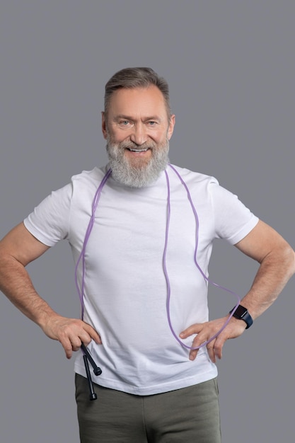 A smiling positive man with a jump rope in hands