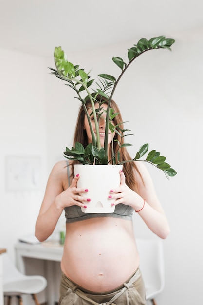 Free photo smiling pregnant woman holding fresh pot