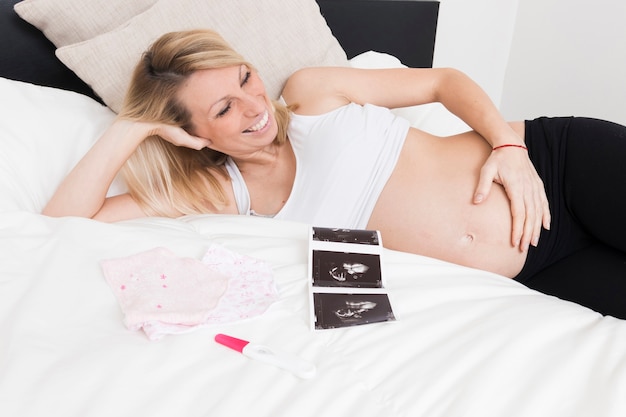 Smiling pregnant woman with ultrasound