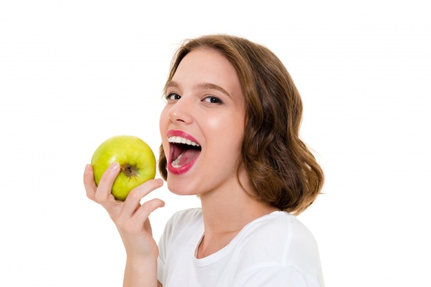 Smiling pretty caucasian woman eating apple