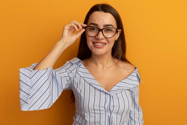 Smiling pretty caucasian woman looks through optical glasses isolated