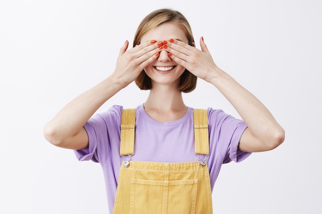 Free photo smiling pretty girl close eyes and waiting for surprise, anticipating something