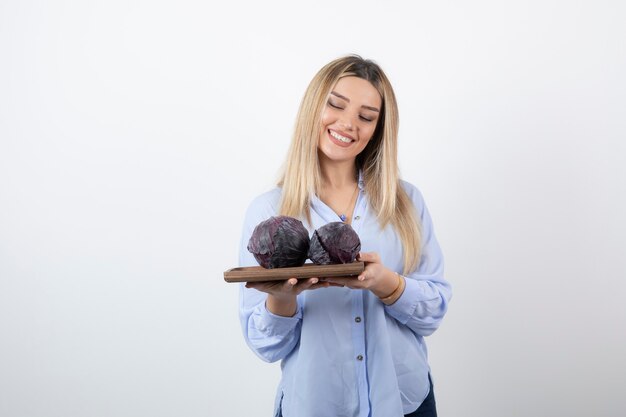 smiling pretty girl model standing and holding cabbage. 