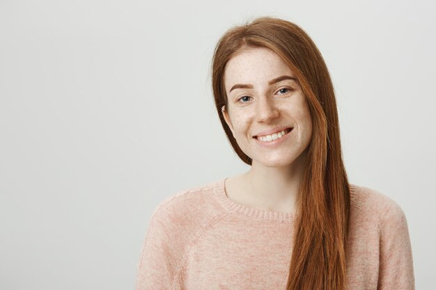 Smiling pretty redhead girl with freckles smiling camera