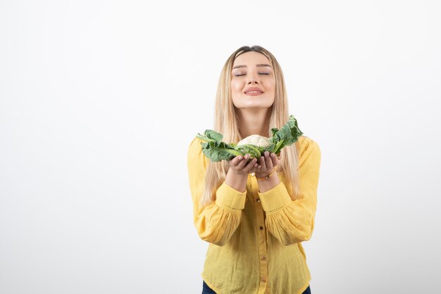 smiling pretty woman model standing and holding cauliflower.