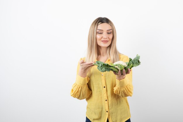 smiling pretty woman model standing and holding cauliflower.