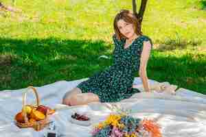 Free photo smiling pretty young woman in hat on picnic in park